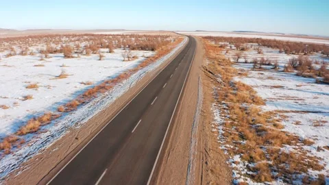 Empty road in the Kazakhstan steppe covered with snow Stock Footage 233396471