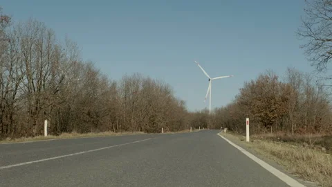 Empty Road Leading to a Wind Turbine Stock Footage 282926682