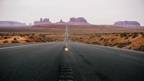 Empty road to Monument Valley in the middle of desert Stock Photos