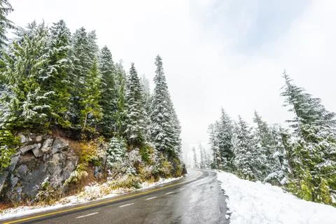 Empty road to the mountain with snow covered landscape in winter season. Stock Photos