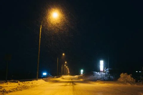 Empty road in night while snowing in winter Foto stock