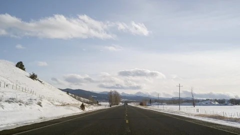 Empty road passing through a snow covered landscape Stock Footage 113235513