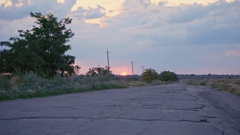 An empty road with poor asphalt surface and potholes between the fields. Stock Footage 121355471