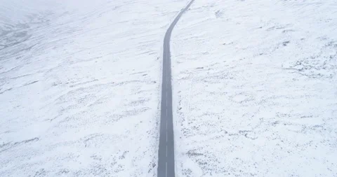 Empty road in a snowy valley Stock Footage 166699553