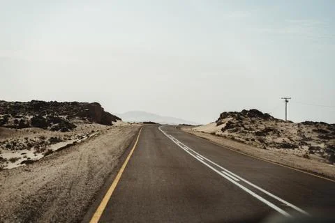 Empty road through the desert dunes with copy space Stock Photos