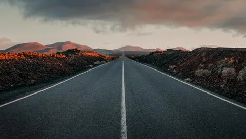 Empty road through the volcanic field at the sunrise with copy space Stock Photos