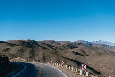 Empty road winds through arid hills Stock Photos