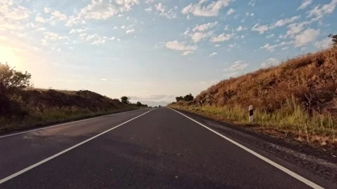 Empty road winds through dry landscape under bright sky Stock Footage 341777002