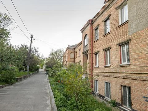 Empty road in yard with old Soviet brick house building of the 1950s. Stock Photos