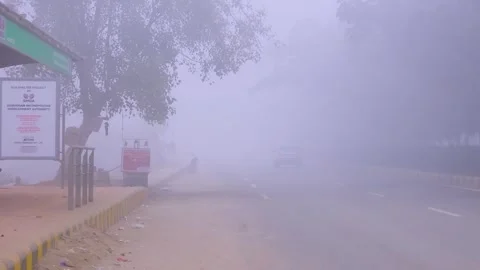 Empty roads near bus stop traffic moving in the low visibility fog smog Stock Footage 331260200