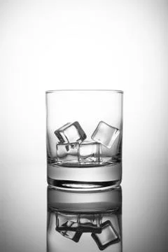 Empty rocks glass with ice-cubes, isolated on white background Stock Photos