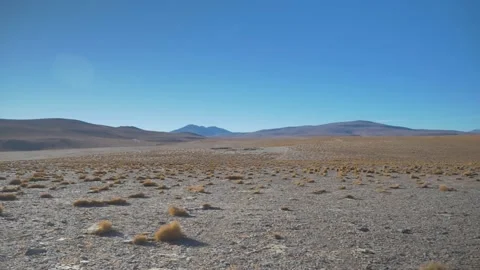 Empty rocky desert with bushes surrounded by mountains, Sur Lipez, Bolivia Stock Footage 237468360
