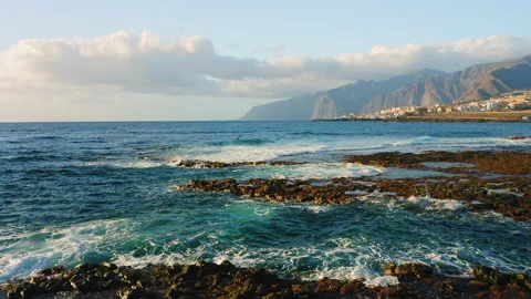 Empty rocky volcanic beach of Atlantic Ocean in the soft morning light, flying Stock Footage 230051390