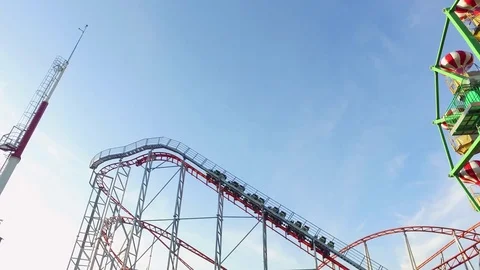 Empty Roller Coaster ride in a large amusement park on a sunny afternoon Video stock 71960459