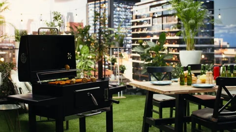 Empty rooftop barbecue setup with grilled food and bottled drinks Stock Footage 347069410