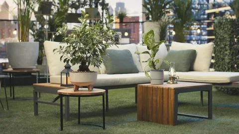 Empty rooftop lounge with potted plants and cushioned seating Stock Photos