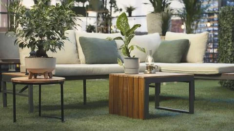 Empty rooftop terrace with lounge seating, plants and wooden furniture Stock Photos