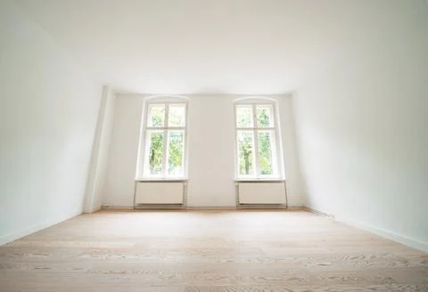 An empty room in an apartment with two windows Stock Photos