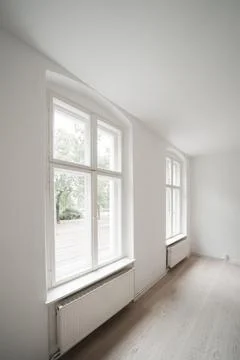 An empty room in an apartment with two windows Foto stock