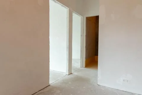 Empty room with bare plastered walls and concrete floor during renovation. .. Stock Photos