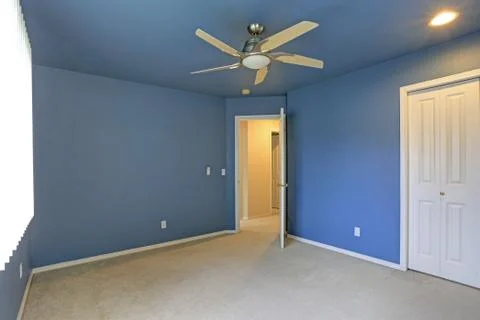Empty room with blue ceiling and blue walls paint color, closet and open door Stock Photos