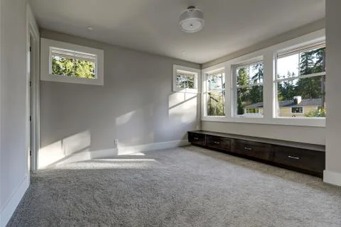 Empty room interior with grey walls paint color, wall to wall carpet floor an Stock Photos