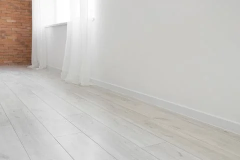 Empty room interior with light wood laminate flooring, white walls, and expos Stock Photos
