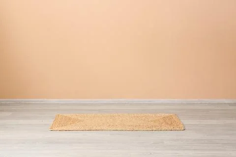 Empty room interior with natural jute doormat on light wooden floor and peach Stock Photos