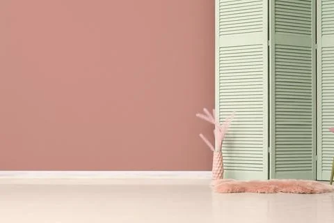 Empty room interior with a pink wall, mint green folding screen, and decorati Stockfoto's