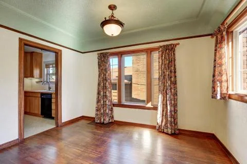 Empty room interior of tudor style home with colorful window curtains Stock Photos