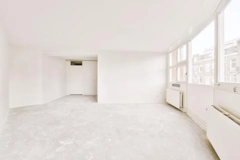 An empty room with a large window and a kitchen Stock Photos