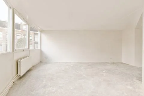 An empty room with a large window and white walls Stock Photos