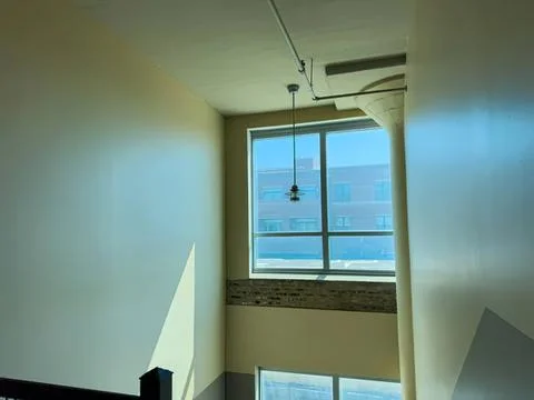 Empty room with large window and hanging light fixture Stock Photos