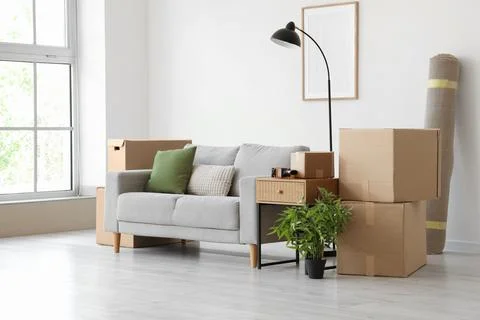 Empty room with moving boxes and furniture, new home relocation and apartment Stock Photos