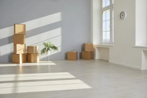 Empty room with moving cardboard boxes on floor Stock Photos