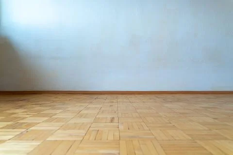 Empty room with plain white wall and vintage wooden parquet floor Stock Photos