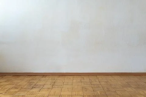Empty room with plain white wall and vintage wooden parquet floor Stock Photos