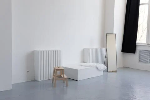 Empty room with radiator and standing mirror Stock Photos