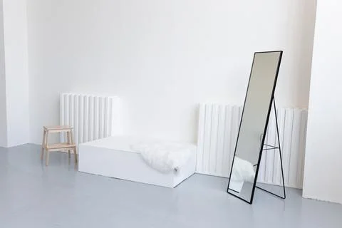 Empty room with white bed and standing mirror Stock Photos
