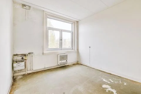 Empty room with window and radiator Stock Photos
