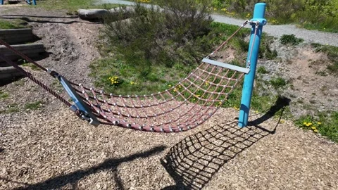Empty rope hammock swing at outdoor playground on sunny day with natural park Stock Footage 335267464