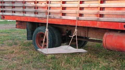 Empty Rope Swing Swaying Beside a Parked Truck Video stock 347369909