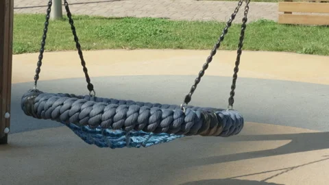 Empty round blue swing seat made of mesh in playground on summer sunny day Stock Footage 247236047