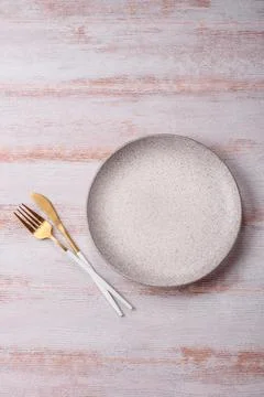 An empty round ceramic plate on a dark, textured white background. An empty.. Stock Photos
