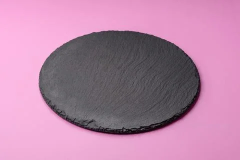 An empty round ceramic plate on a pink background as a kitchen utensil. An .. Stock Photos
