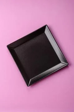 An empty round ceramic plate on a pink background as a kitchen utensil. An .. Stock Photos
