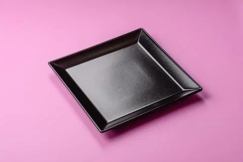 An empty round ceramic plate on a pink background as a kitchen utensil. An .. Stock Photos