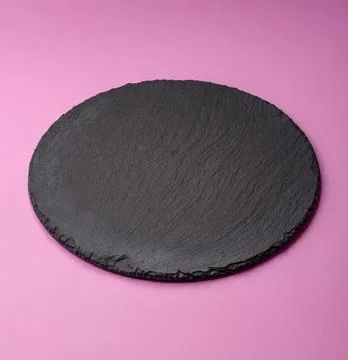 An empty round ceramic plate on a pink background as a kitchen utensil. An .. Stock Photos