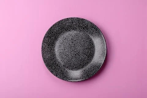An empty round ceramic plate on a pink background as a kitchen utensil. An .. Stock Photos