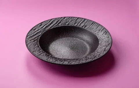 An empty round ceramic plate on a pink background as a kitchen utensil. An .. Stock Photos